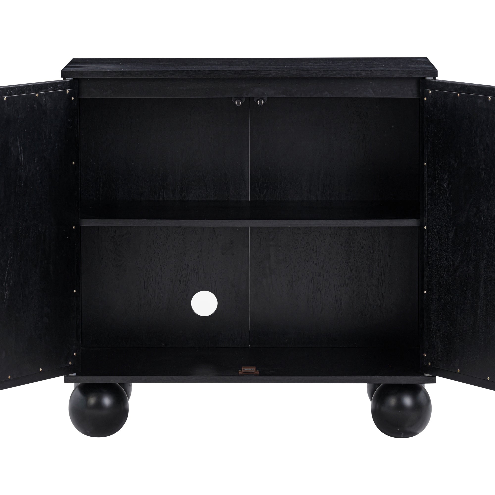 A black wooden cabinet with two open doors, a shelf inside, a circular cutout in the back panel for cables, and round ball-shaped legs.
