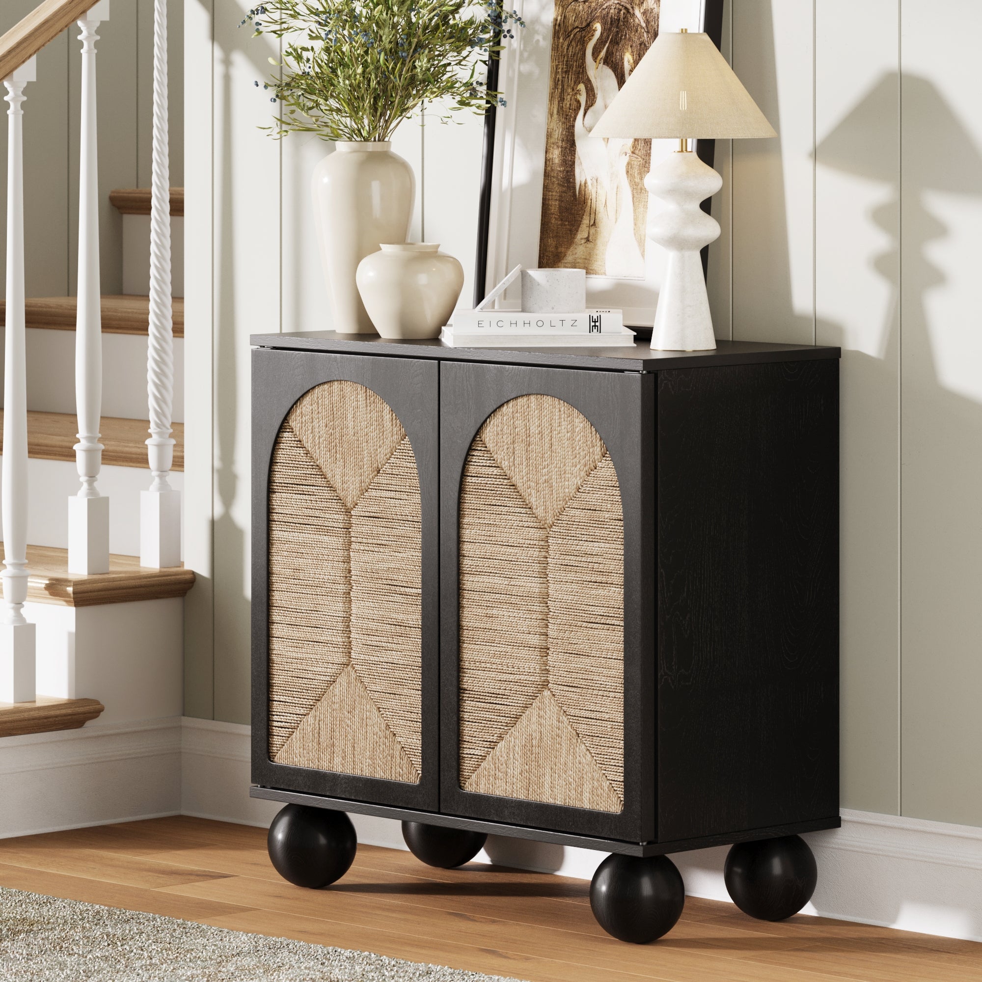 The Nathan James Seagrass Arched Storage Cabinet in black features two baskets and displays a lamp on top.