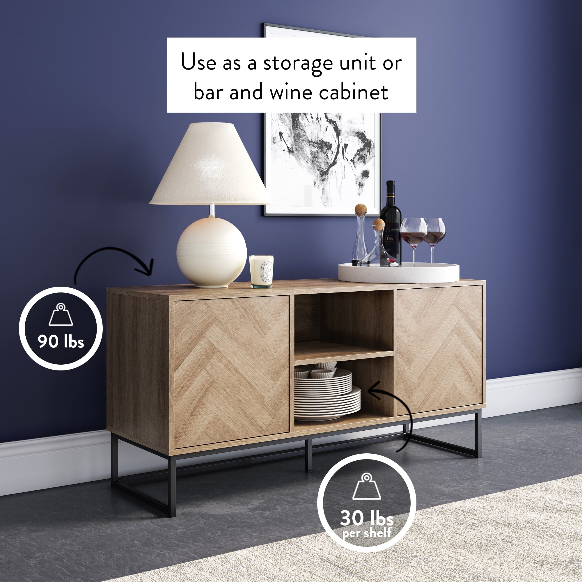 A modern wooden sideboard with a lamp, wine bottles, and glasses on top, highlighting 90 lbs weight limit for the top surface and 30 lbs per shelf, against a dark blue wall with framed art.