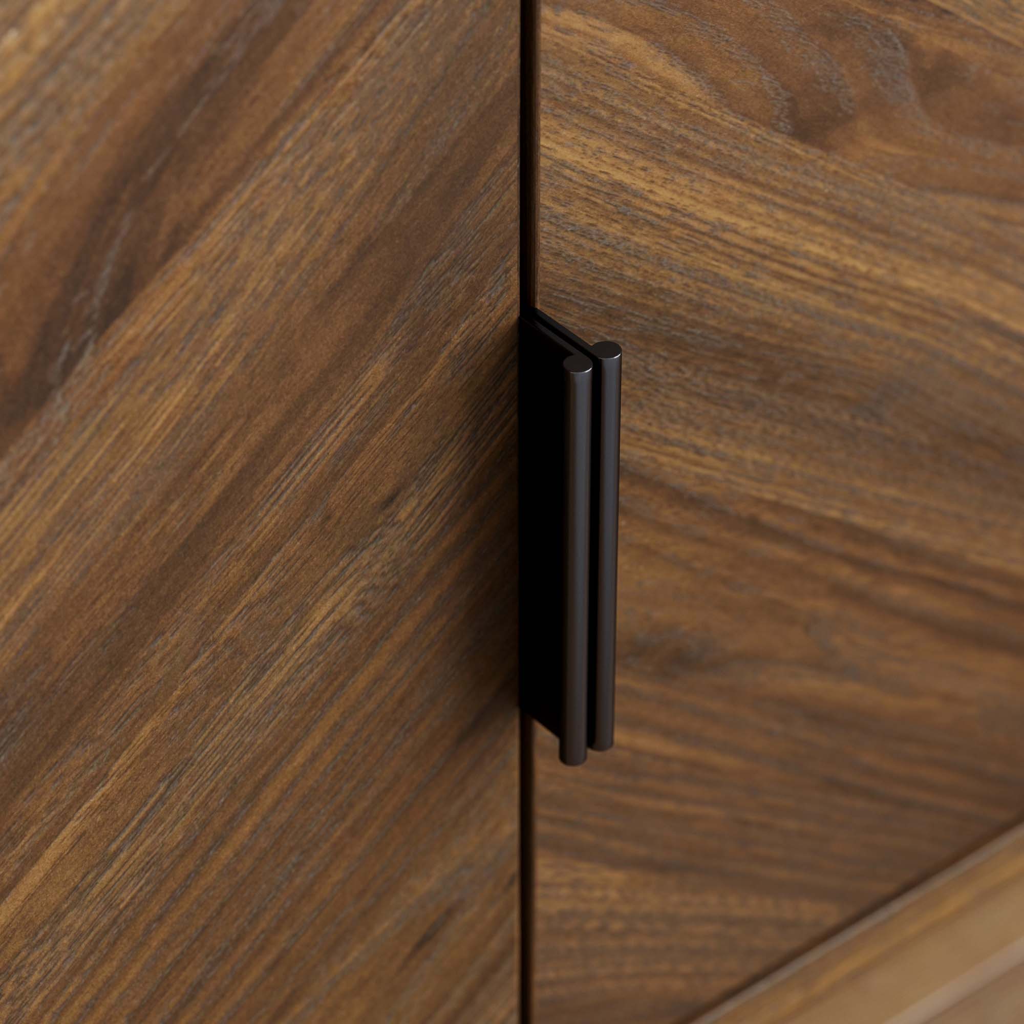 Close-up of a wooden cabinet with a vertical black metal handle attached to the door. The wood has a natural, brown grain pattern.