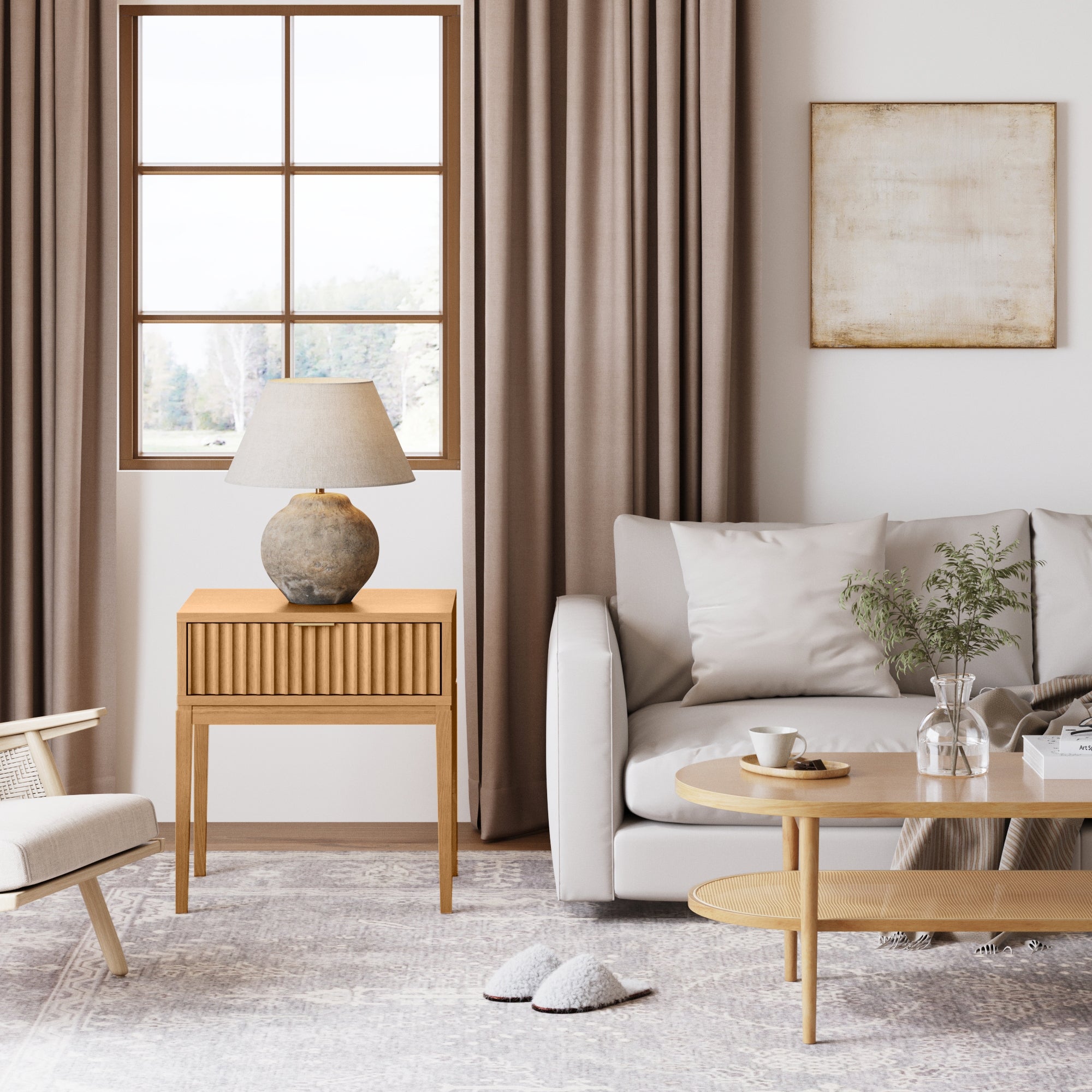 A cozy living room with a white sofa, beige cushions, wooden coffee table, lamp on a Nathan James Mid-Century Fluted Nightstand in Warm Pine, armchair, slippers on a light rug, brown curtains, and sunlight streaming through the window.