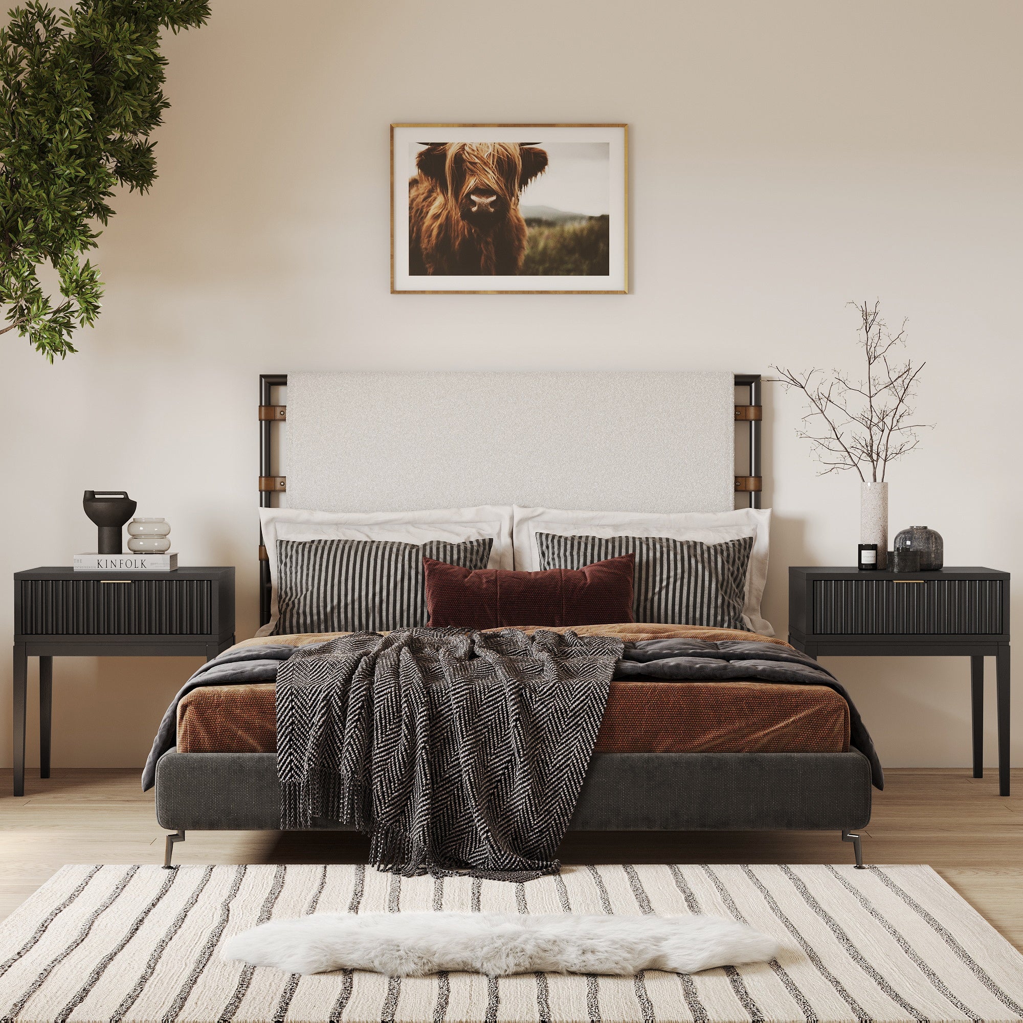 Modern bedroom with a neutral palette, double bed with striped pillows and throw blanket, black nightstands, decorative objects, a plant, and a framed photo of a highland cow above the bed. Striped rug on wooden floor.