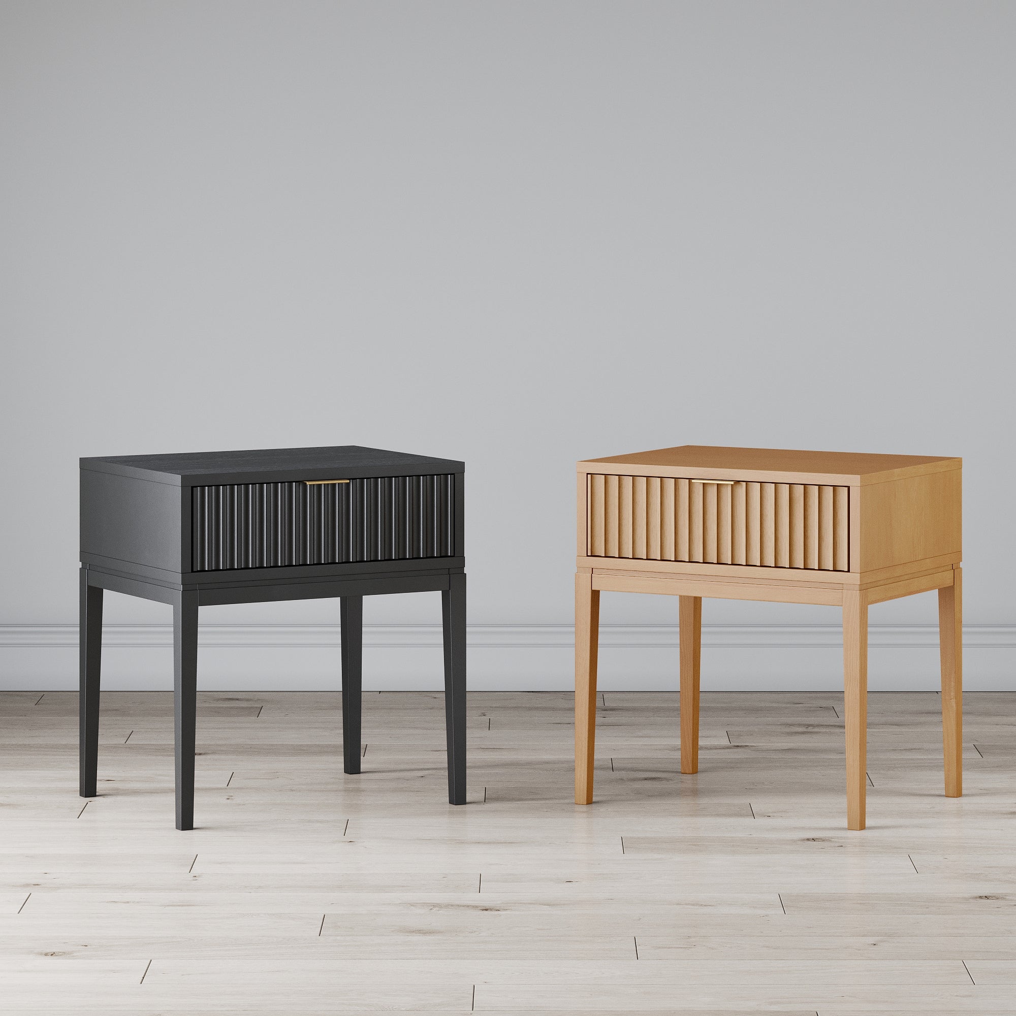 Two modern wooden nightstands stand side by side on a light wood floor; one is black and the other is light wood. Both have vertical grooves on the front and slim, tapered legs against a plain light gray wall.