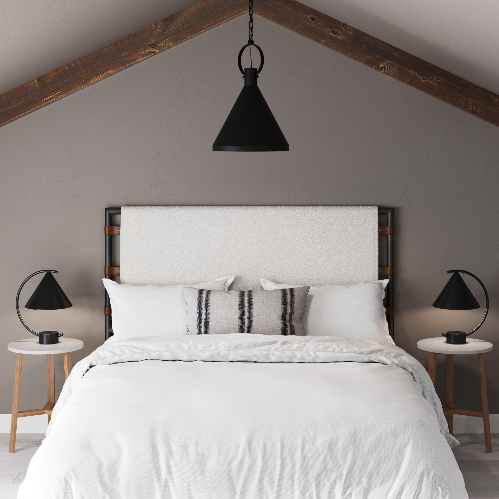 A modern bedroom features the Boucle Queen Upholstered Headboard by Nathan James with white bedding, round side tables with black lamps, exposed wood beams, a black pendant light on the sloped ceiling, and a striped accent pillow.
