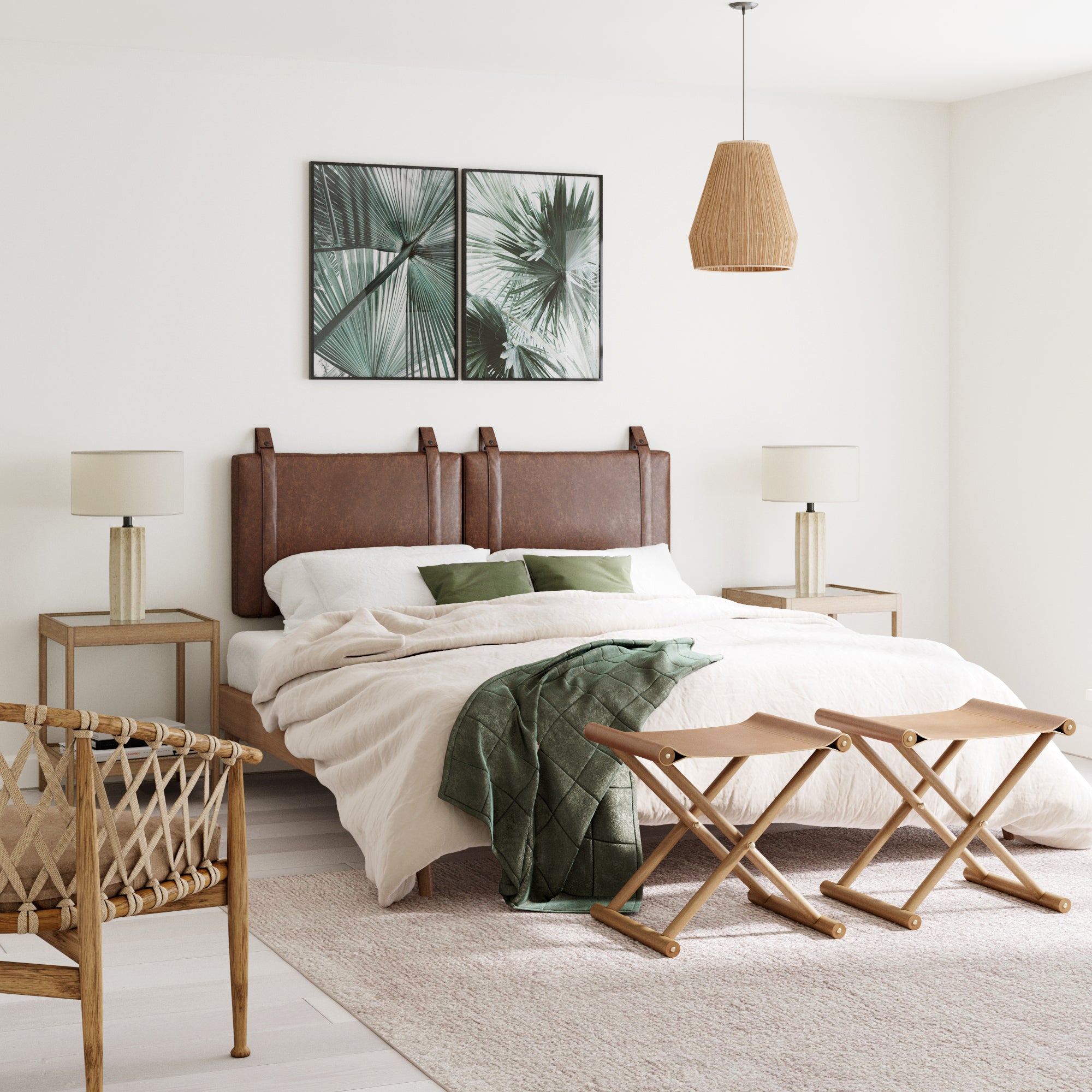 A modern bedroom with a large bed featuring a brown leather headboard, two nightstands with lamps, a wicker chair, a green throw blanket, two palm leaf artworks on the wall, and a woven pendant light.