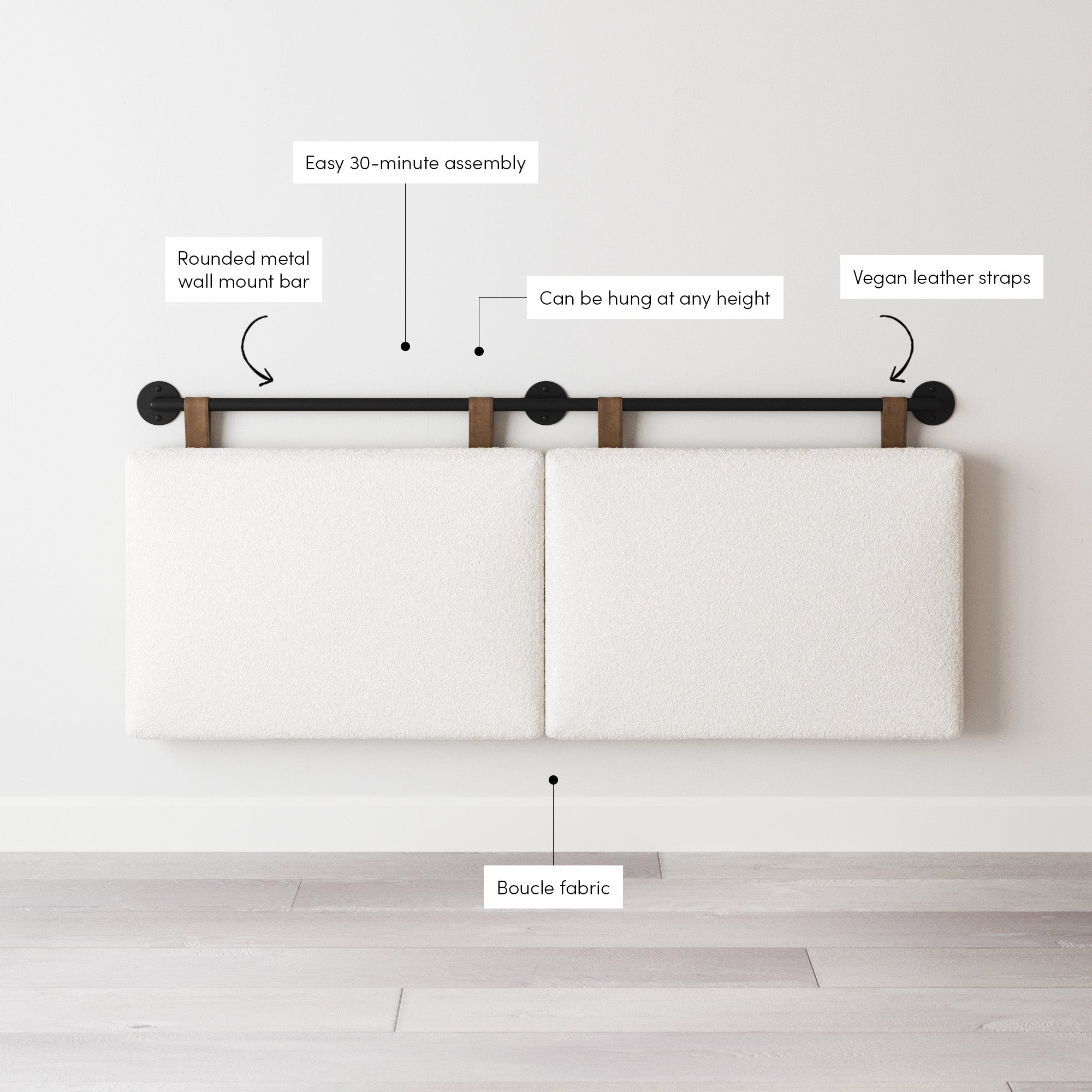 Two rectangular white cushioned panels hang from a black metal wall mount bar using brown vegan leather straps. Labels highlight features: easy assembly, adjustable height, boucle fabric, and vegan leather straps.