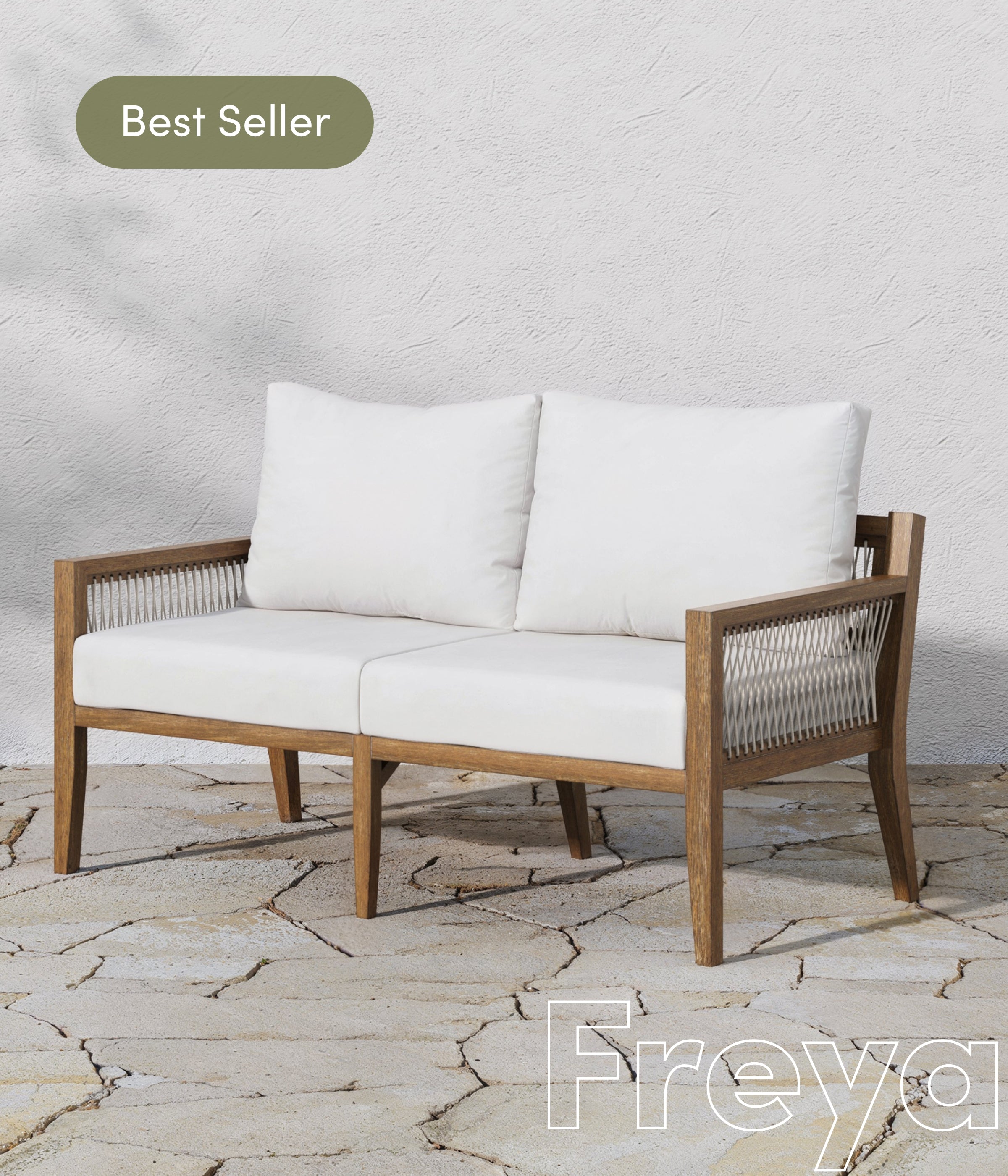 A modern outdoor loveseat with white cushions and wooden frame sits on a stone patio. A “Best Seller” label appears in the top left, and the word “Freya” is written in large letters at the bottom right.
