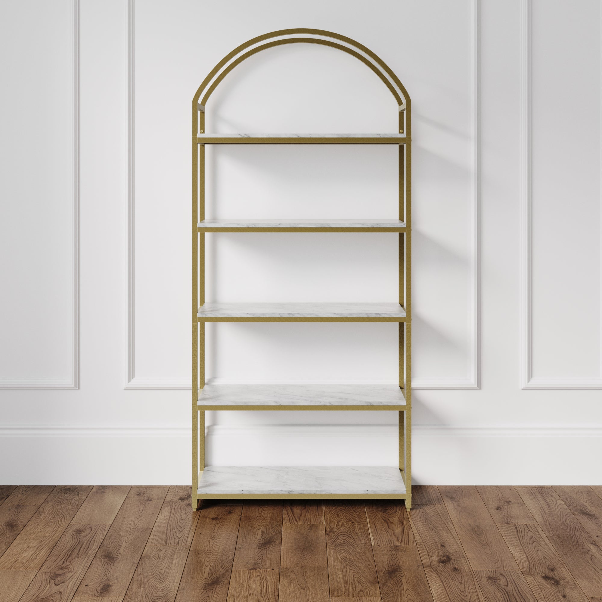 The Nathan James Metal 5-Shelf Arched Bookshelf Gold features a gold metal frame with a rounded arch design and five faux white marble shelves, standing elegantly against a paneled white wall on a wooden floor.