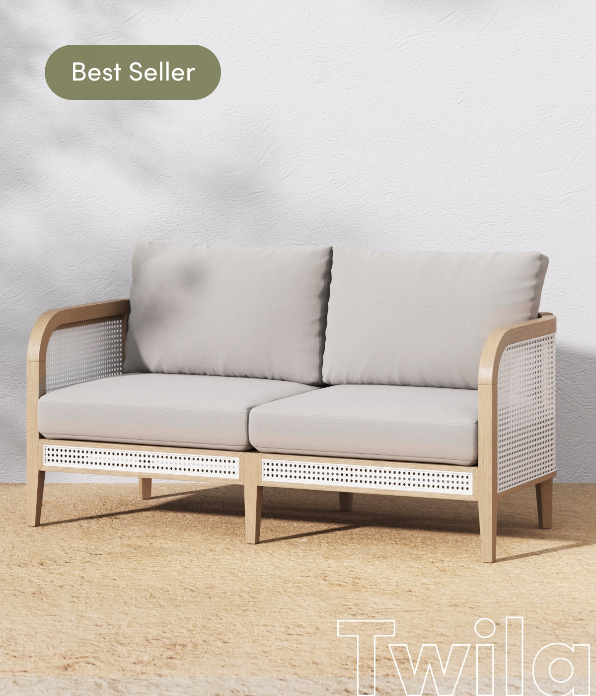 A modern two-seater sofa with light wood frame, beige cushions, and white wicker sides sits on a tan rug against a white wall. A green Best Seller label appears in the top left corner.