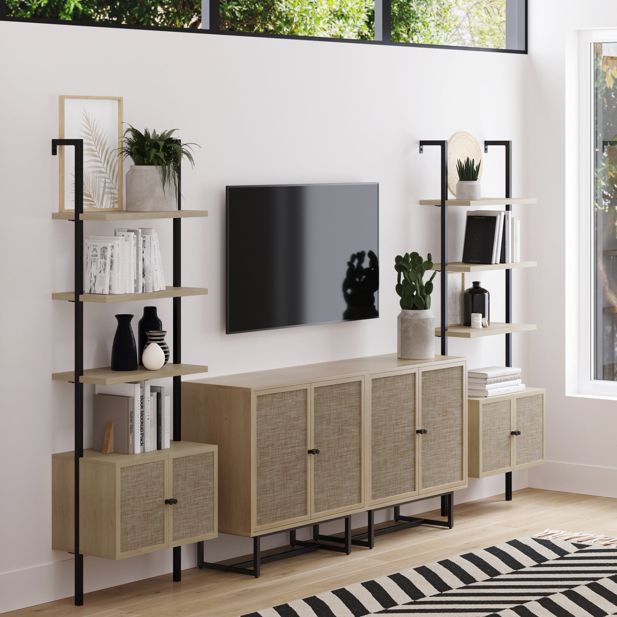 A modern living room featuring a flat-screen TV between two Nathan James Rattan Ladder Wall Bookshelves with Doors (Light Oak), providing space-saving storage for books and décor, plus a matching four-door cabinet below.