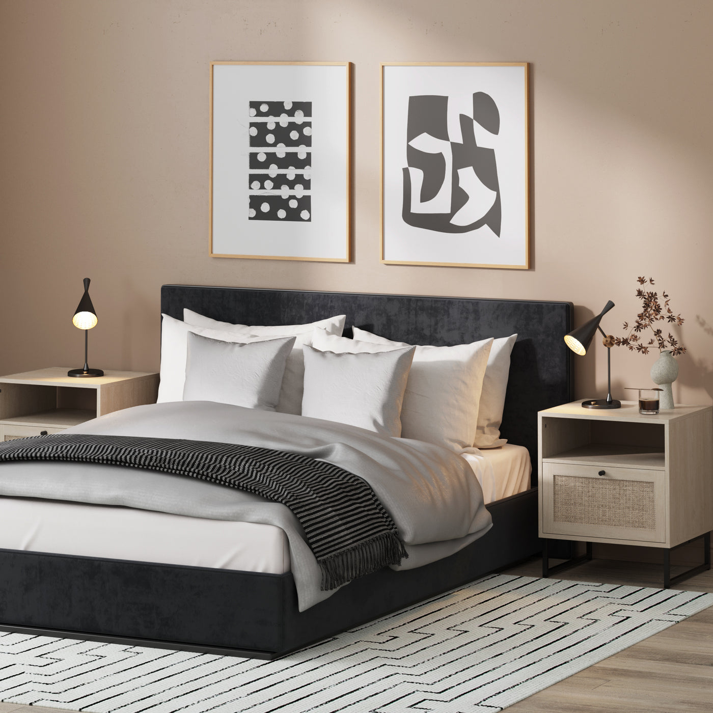 A modern bedroom with a dark upholstered bed, white and gray bedding, two light wood nightstands, black lamps, abstract art on the wall, and a geometric rug on the floor. Dried branches in a vase sit on one nightstand.