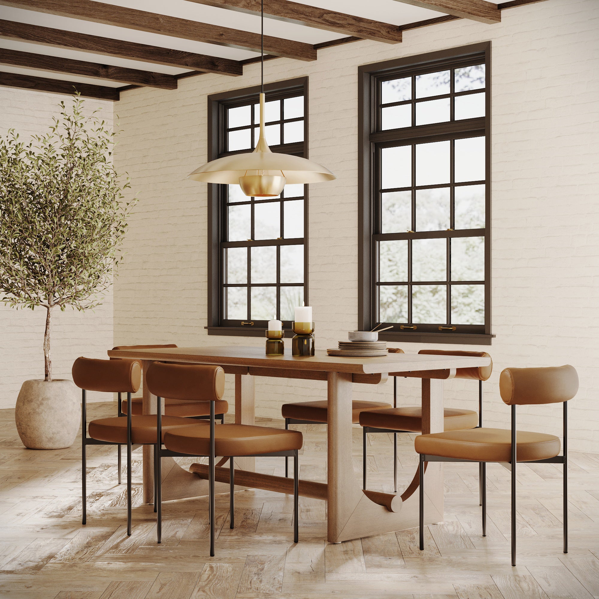 A modern dining room featuring the Nathan James Dining Room Set for 6 with light brown faux leather chairs, a pendant light, stacked plates, candles, and a large potted tree by tall black-framed windows.