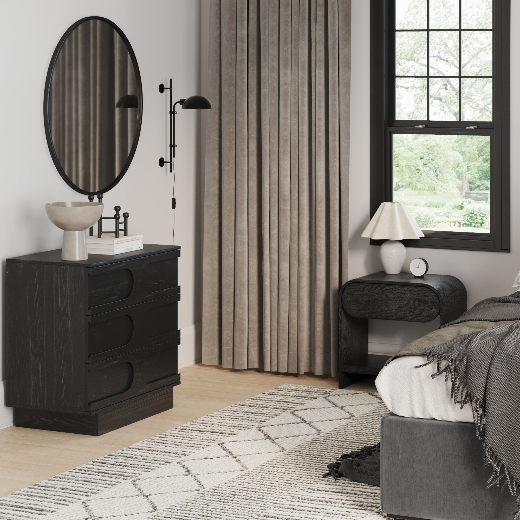 Modern bedroom featuring the Nathan James Mid-Century Arched Dresser and Two Nightstands Set in Black Oak. A round mirror, gray bedding, beige curtains, a patterned rug, and light wood floors complete the look with stylish accents.