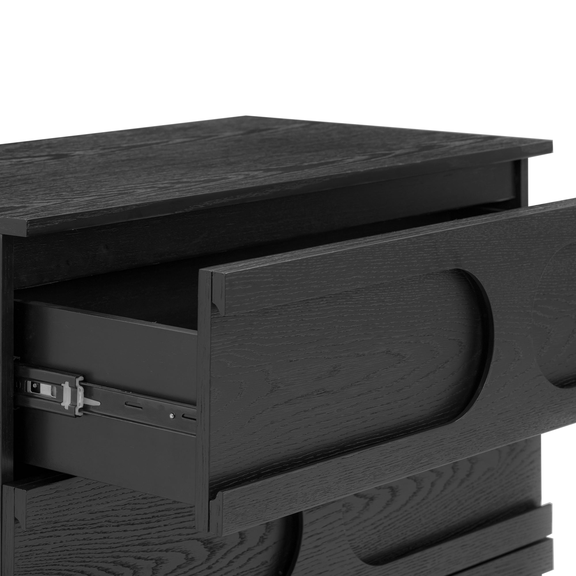 Close-up of a black wooden dresser with one drawer partially open, showing the drawer’s metal slide mechanism. The dresser has a modern design with a smooth finish and curved cutout handles.