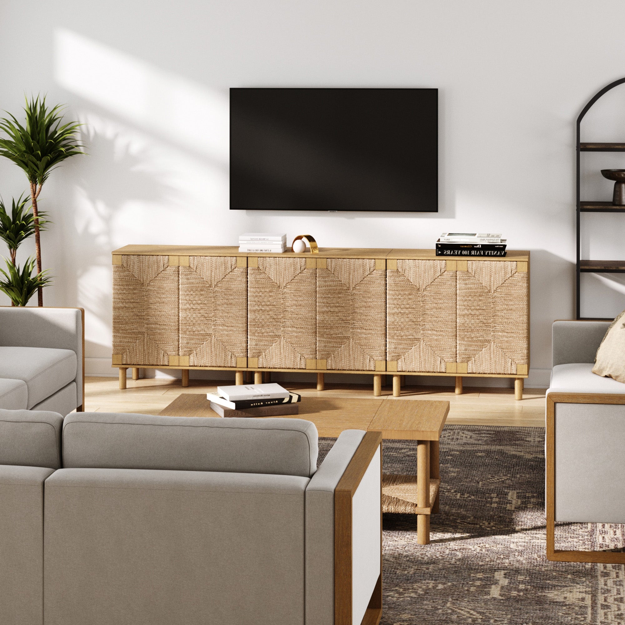 Modern living room with a textured wooden sideboard under a wall-mounted TV, surrounded by light gray sofas, a wooden coffee table, indoor plant, and a dark metal shelf on the right.